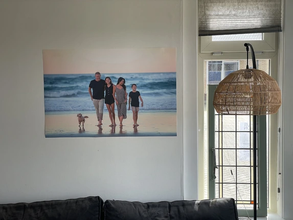 Strandfoto gezin met hond als poster geprint opgehangen met handige kleefstrips.